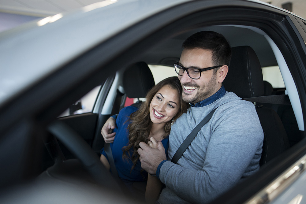 Hombre feliz luego de asegurar su vehículo